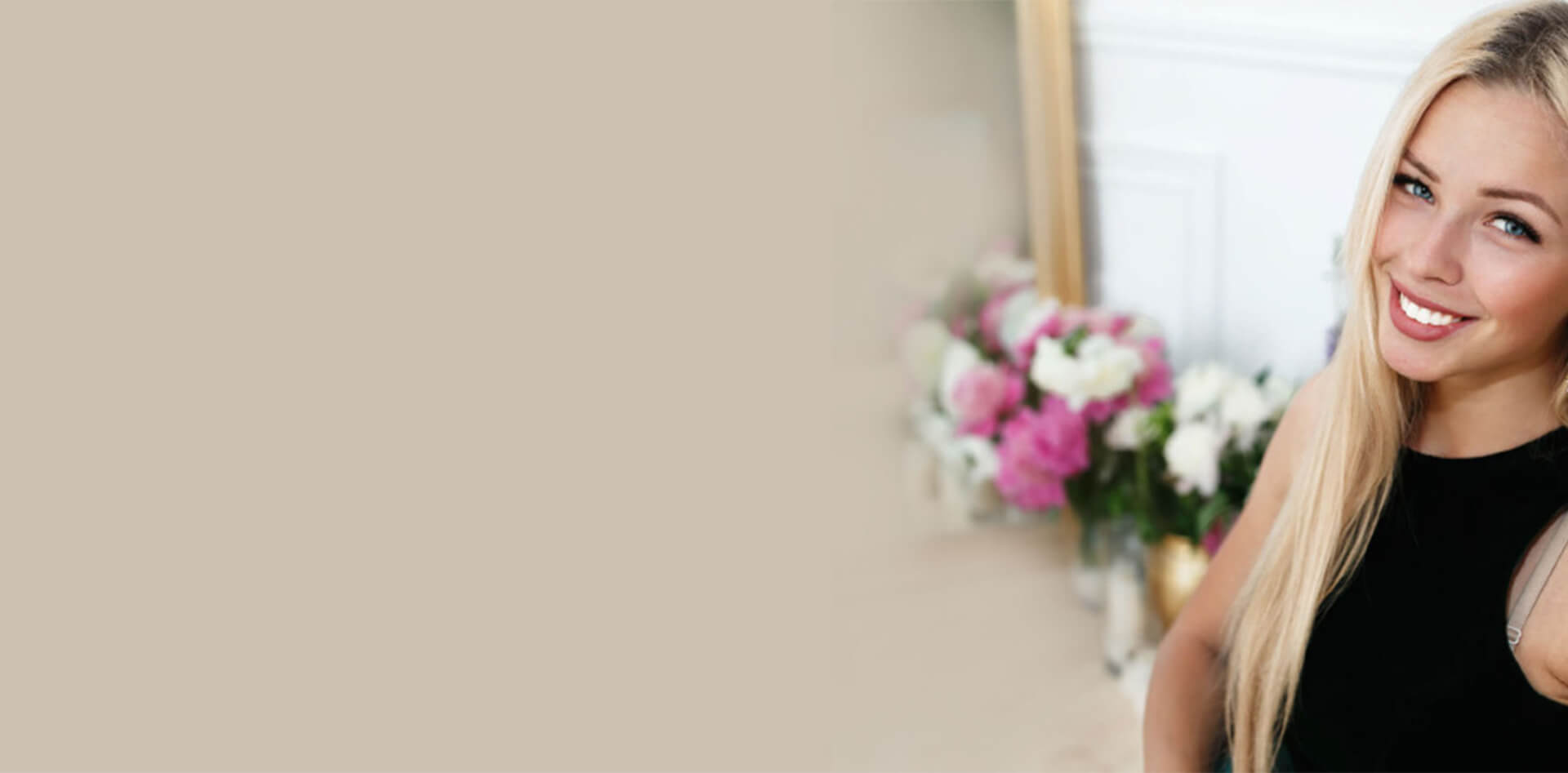 Smiling woman with long blonde hair in a black top, surrounded by flowers, representing cosmetic dentistry and patient satisfaction at PGA Dentistry.