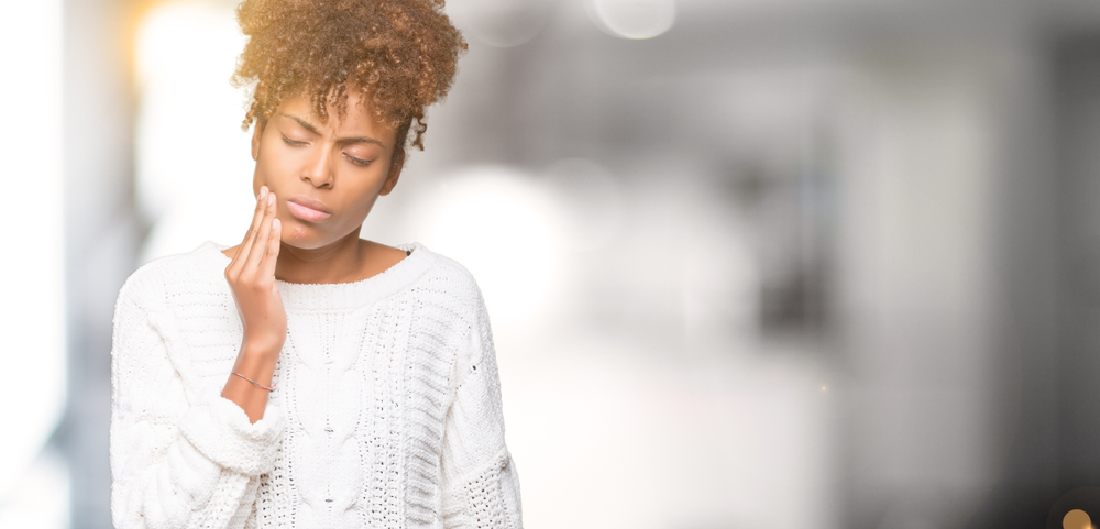 woman dealing with mouth pain and a dental emergency